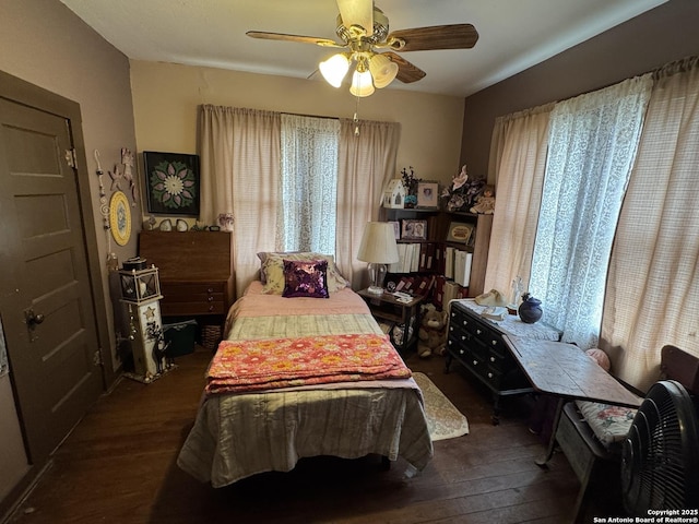 bedroom with multiple windows, dark wood finished floors, and a ceiling fan