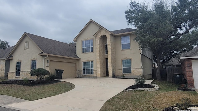 view of front of home featuring an attached garage, stone siding, concrete driveway, and stucco siding