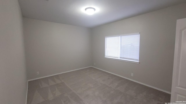 empty room featuring carpet and baseboards