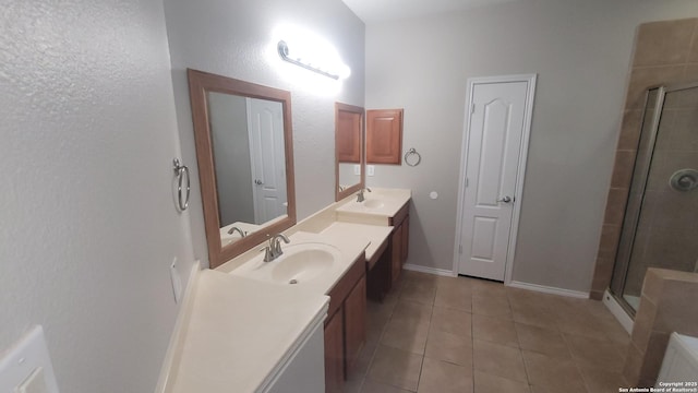 full bathroom featuring a sink, double vanity, a shower stall, and tile patterned floors