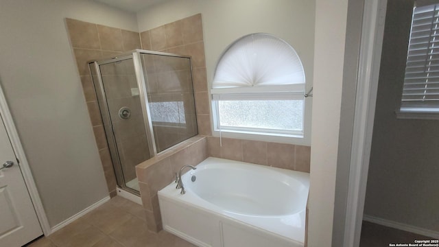 full bathroom featuring a garden tub, a shower stall, baseboards, and tile patterned floors