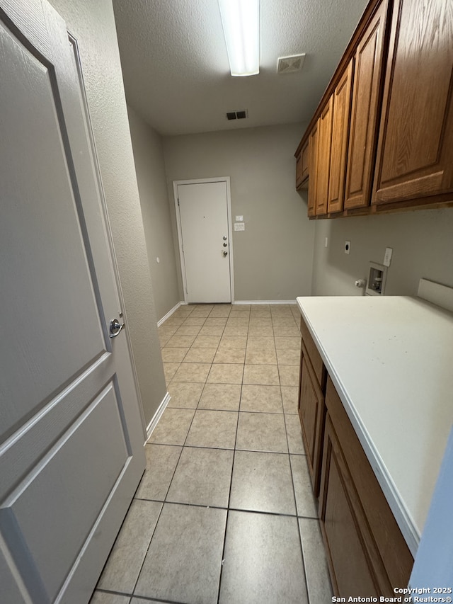 washroom featuring light tile patterned floors, hookup for a washing machine, cabinet space, visible vents, and hookup for an electric dryer