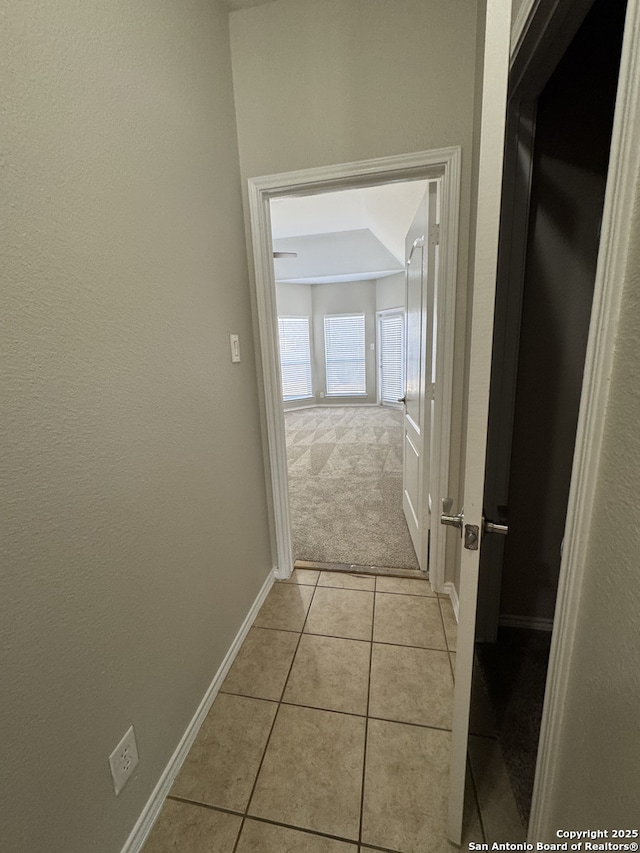 hallway featuring baseboards and light tile patterned floors