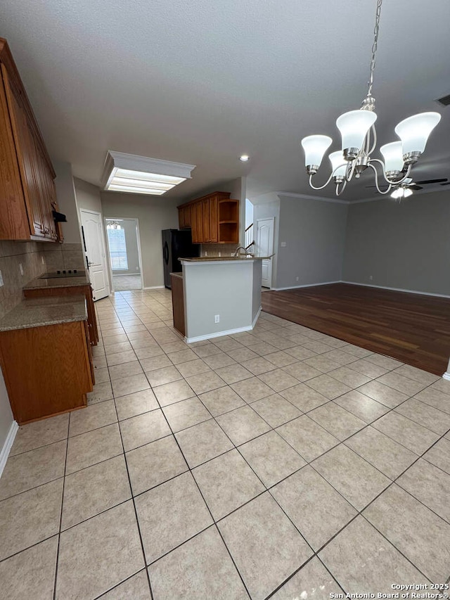 kitchen with open shelves, dark countertops, brown cabinetry, freestanding refrigerator, and light tile patterned flooring