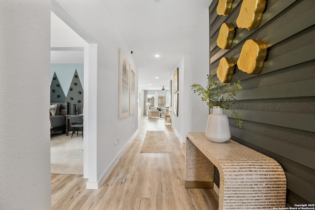 hallway featuring baseboards, recessed lighting, and light wood-style floors