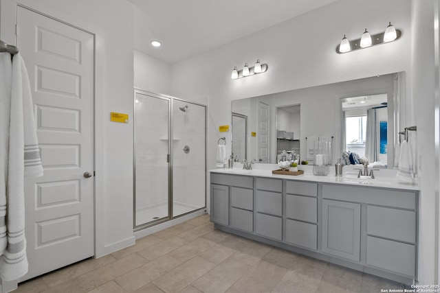 ensuite bathroom featuring a stall shower, double vanity, a sink, and ensuite bathroom