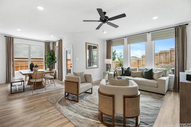 living room with light wood-style floors, ceiling fan, baseboards, and recessed lighting