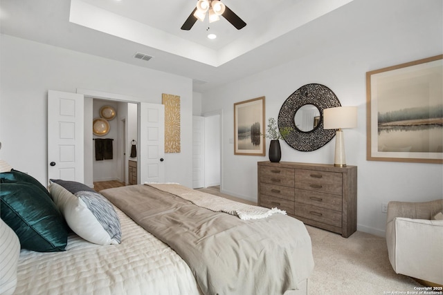 bedroom featuring recessed lighting, light colored carpet, visible vents, baseboards, and a tray ceiling