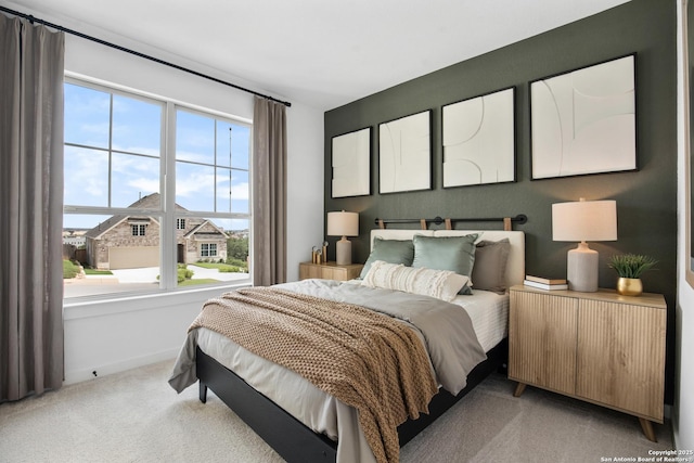 bedroom with radiator, baseboards, and light colored carpet