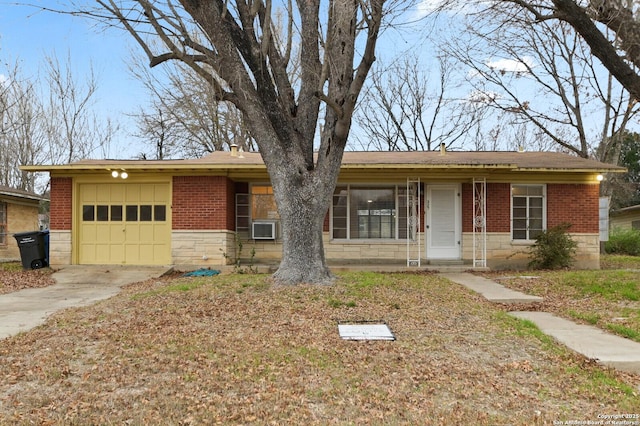 single story home featuring an attached garage, stone siding, concrete driveway, and brick siding