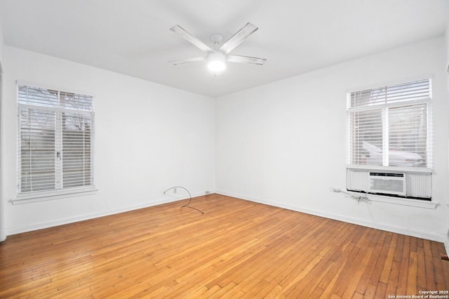 spare room featuring cooling unit, ceiling fan, baseboards, and wood finished floors