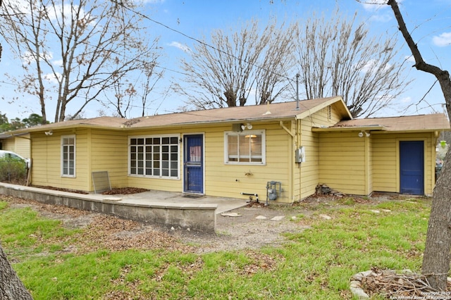 rear view of house featuring a patio and a lawn