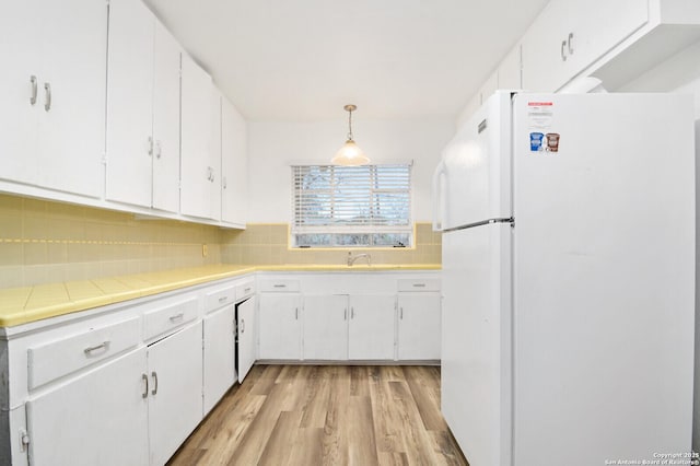 kitchen with white cabinetry and freestanding refrigerator