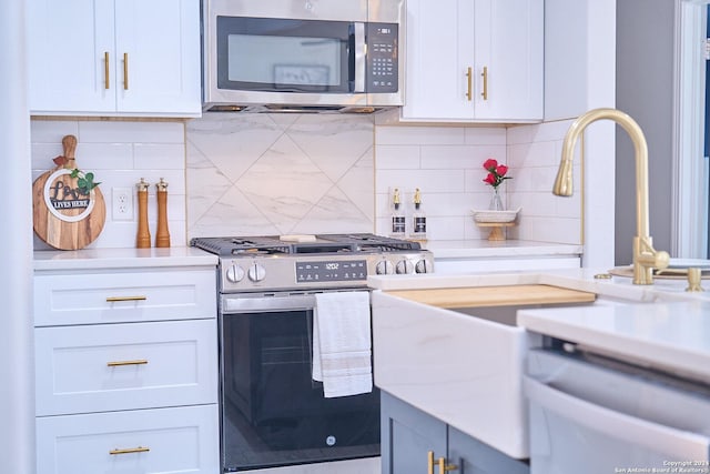 kitchen with appliances with stainless steel finishes, backsplash, and white cabinetry