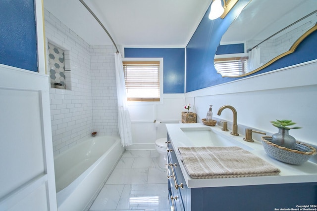 bathroom with marble finish floor, shower / bath combination with curtain, toilet, wainscoting, and vanity