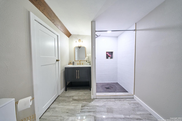 bathroom featuring toilet, a stall shower, a textured wall, and vanity