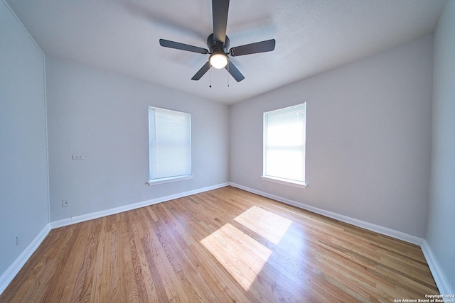 unfurnished room featuring light wood-type flooring, ceiling fan, and baseboards