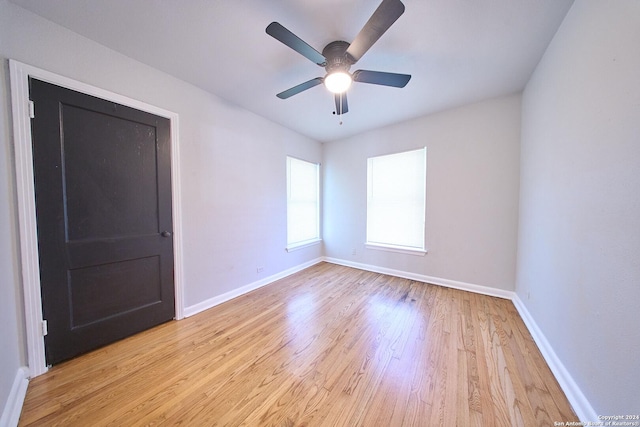 unfurnished room featuring light wood-type flooring, ceiling fan, and baseboards