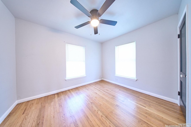 unfurnished room with light wood-style floors, plenty of natural light, and baseboards