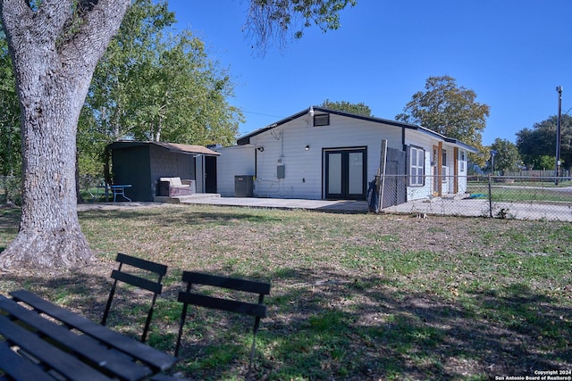 rear view of house featuring an outbuilding, french doors, central AC unit, a patio area, and fence