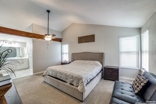 bedroom featuring carpet floors, lofted ceiling, baseboards, and ensuite bathroom