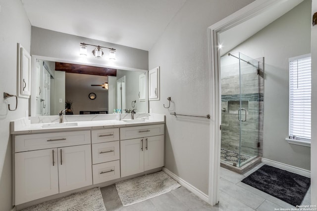 full bath with a stall shower, a sink, baseboards, and double vanity