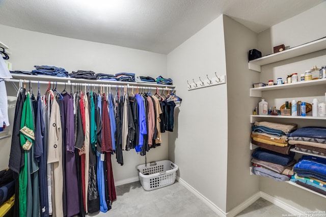 spacious closet featuring light colored carpet