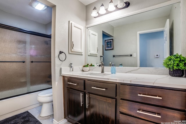 bathroom with toilet, tile patterned flooring, combined bath / shower with glass door, and vanity