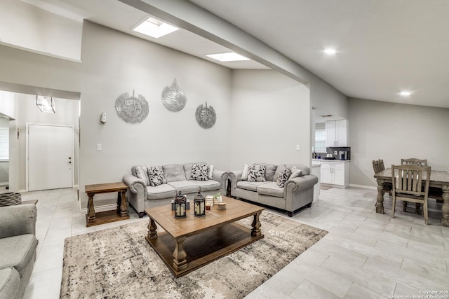 living area with lofted ceiling with skylight, light tile patterned floors, baseboards, and recessed lighting