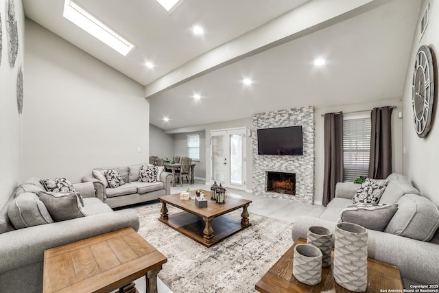 living area featuring a large fireplace, high vaulted ceiling, a skylight, and recessed lighting