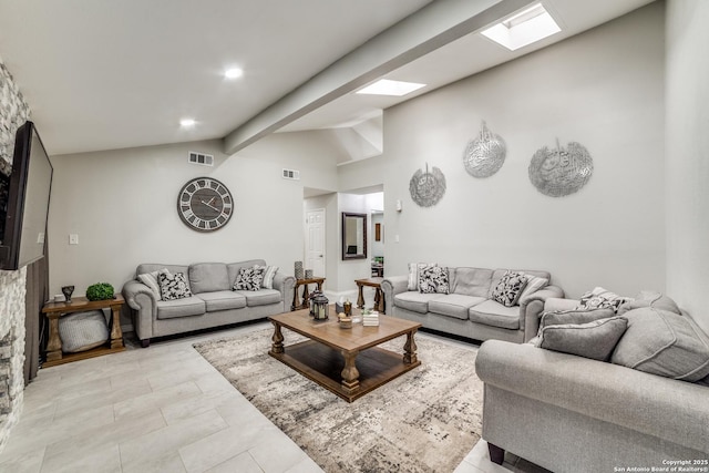 living area featuring high vaulted ceiling, a skylight, and visible vents