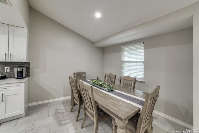 dining space with vaulted ceiling, light tile patterned flooring, visible vents, and baseboards