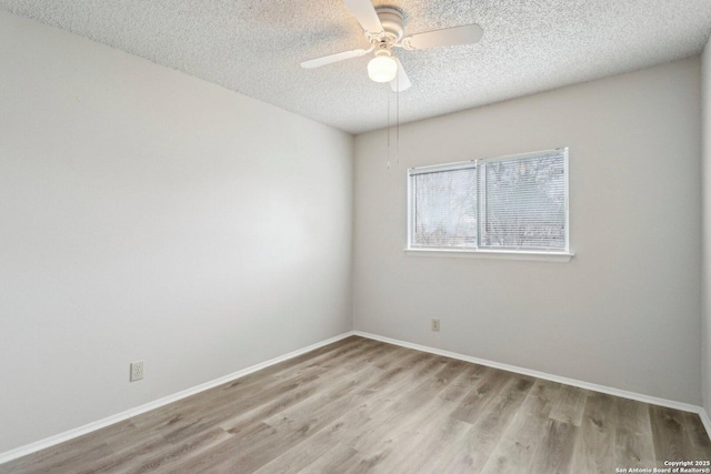 empty room featuring baseboards, ceiling fan, a textured ceiling, and light wood finished floors