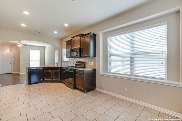 kitchen with light tile patterned floors, tasteful backsplash, arched walkways, baseboards, and black appliances