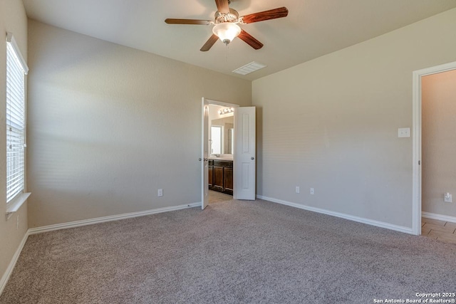 unfurnished room with ceiling fan, a healthy amount of sunlight, visible vents, and light colored carpet