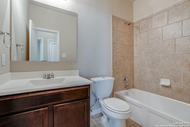 bathroom with bathing tub / shower combination, a textured wall, toilet, vanity, and tile patterned floors