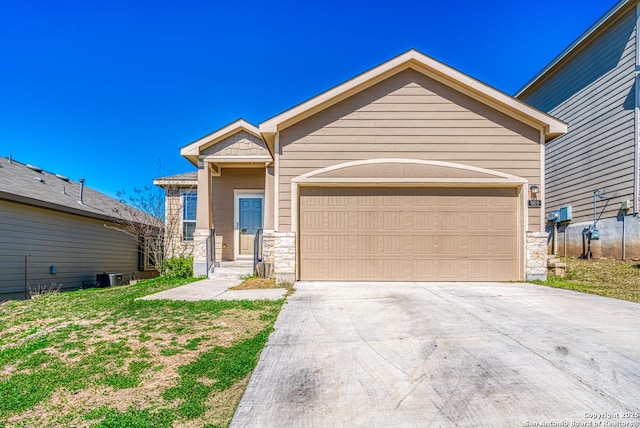 view of front facade featuring a garage, stone siding, central AC unit, and concrete driveway