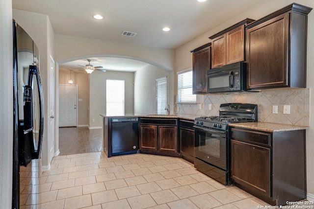 kitchen with arched walkways, tasteful backsplash, visible vents, dark brown cabinetry, and black appliances