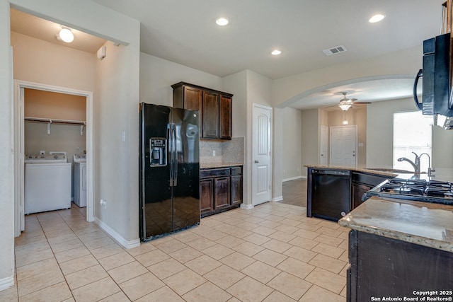 kitchen with arched walkways, dark brown cabinets, light countertops, backsplash, and black appliances