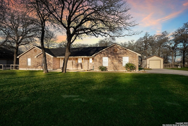 single story home featuring driveway, a detached garage, a front lawn, and an outdoor structure