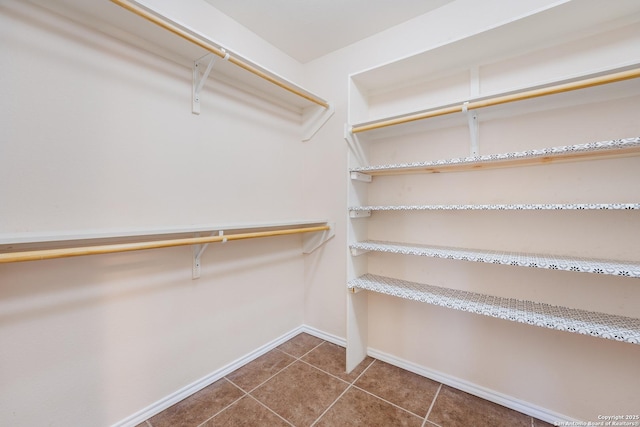 spacious closet with dark tile patterned floors