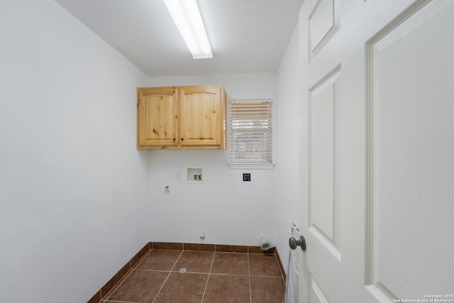 clothes washing area featuring washer hookup, hookup for a gas dryer, cabinet space, dark tile patterned flooring, and baseboards