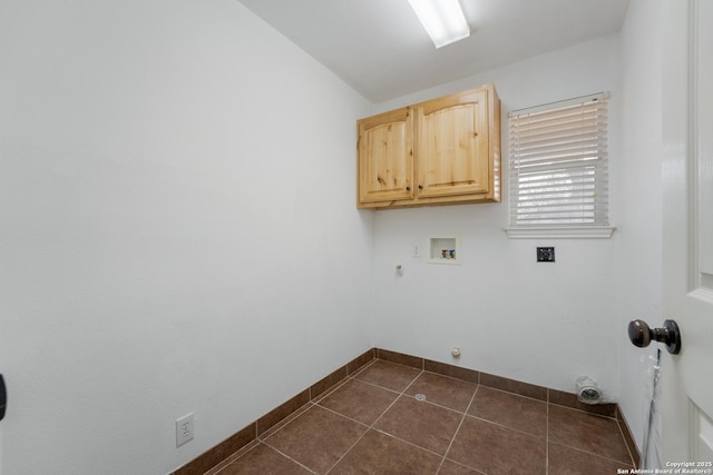 laundry room featuring cabinet space, baseboards, dark tile patterned flooring, hookup for a gas dryer, and washer hookup