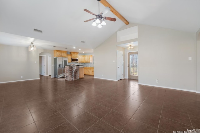 unfurnished living room featuring baseboards, visible vents, arched walkways, dark tile patterned floors, and beam ceiling