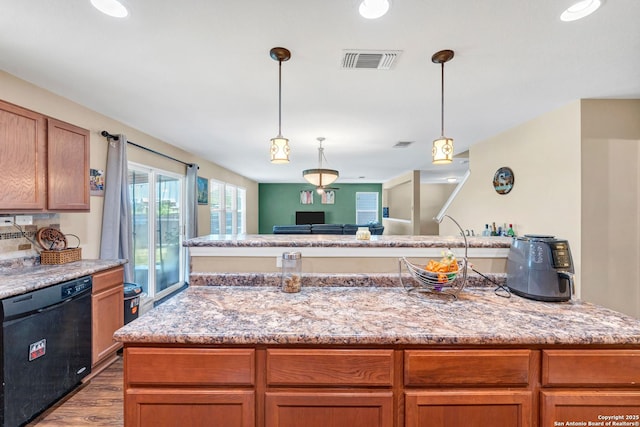 kitchen featuring brown cabinetry, visible vents, light stone counters, and dishwasher