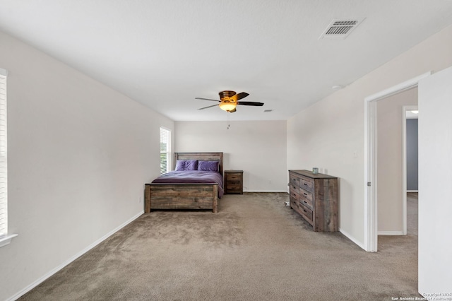 bedroom featuring light carpet, a ceiling fan, visible vents, and baseboards