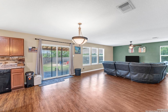 living area featuring dark wood-style floors, a healthy amount of sunlight, visible vents, and baseboards