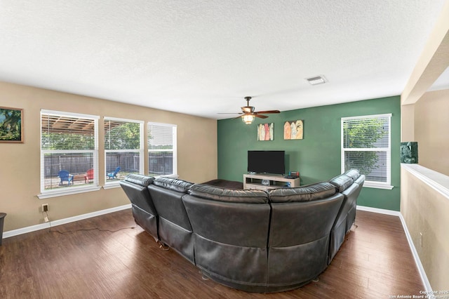 living area with dark wood-style floors, a wealth of natural light, and visible vents