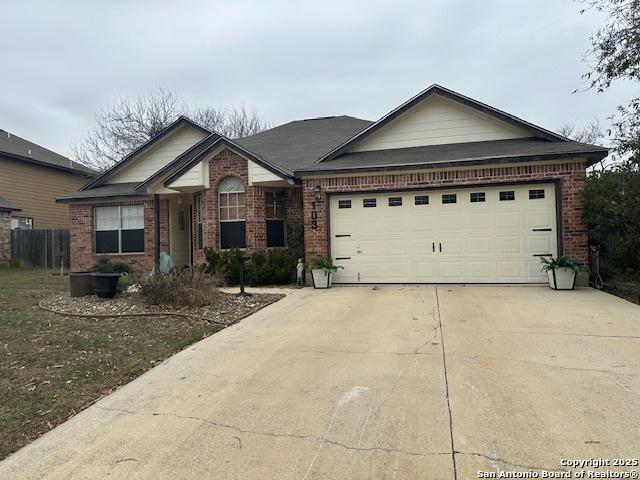 single story home with a garage, concrete driveway, and brick siding