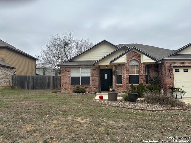 view of front of home with a garage, fence, a front lawn, and brick siding